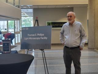Dr. Tom Phillips next to new sign for facility named in his honor